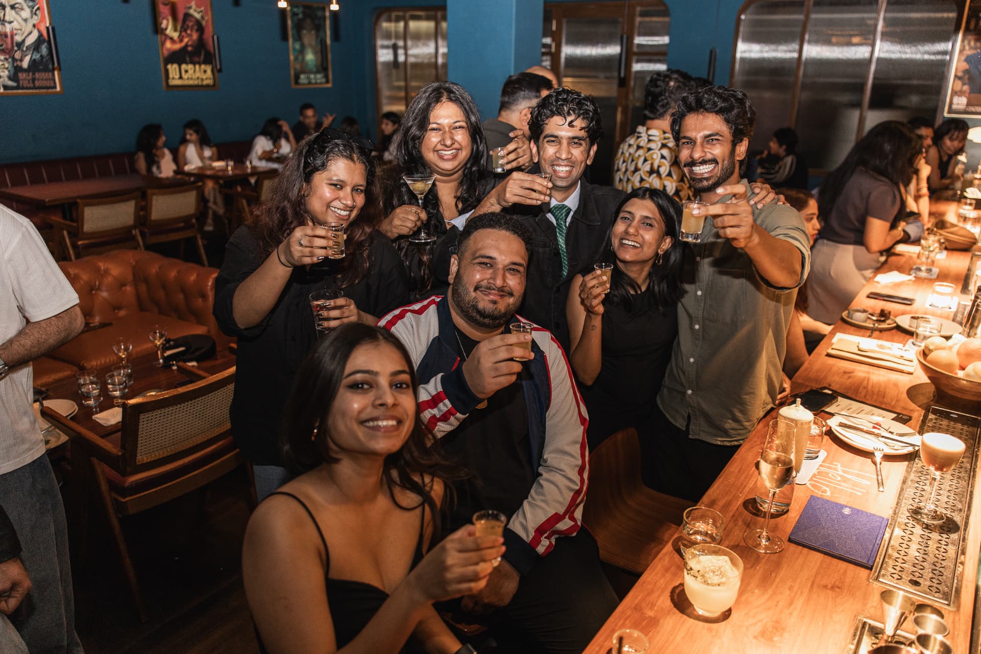 Group of guests raising shots at the bar