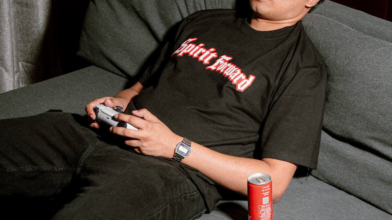 Spirit Forward tee on the couch with a controller